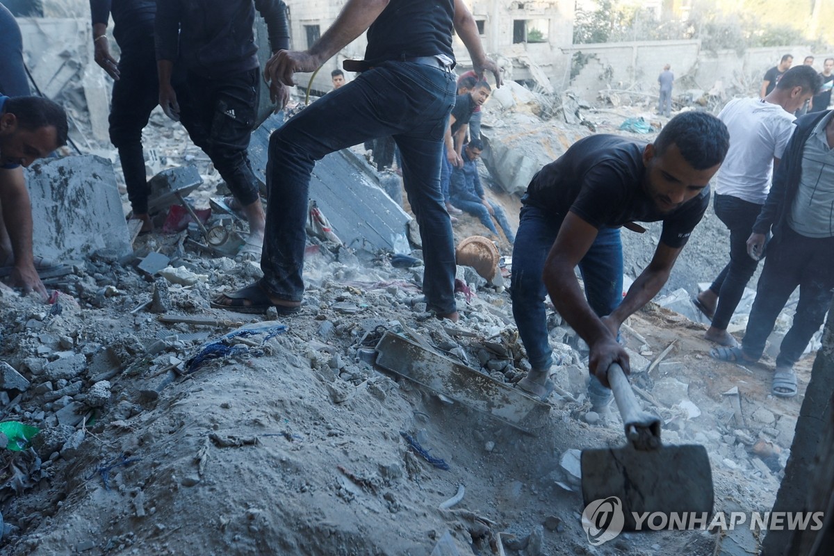 파괴된 건물 잔해 수습하는 가자지구 주민들